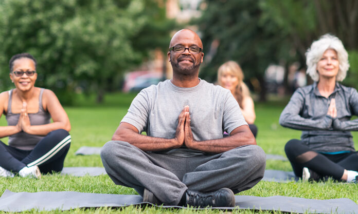 Multi-ethnic group of seniors meditating outdoors