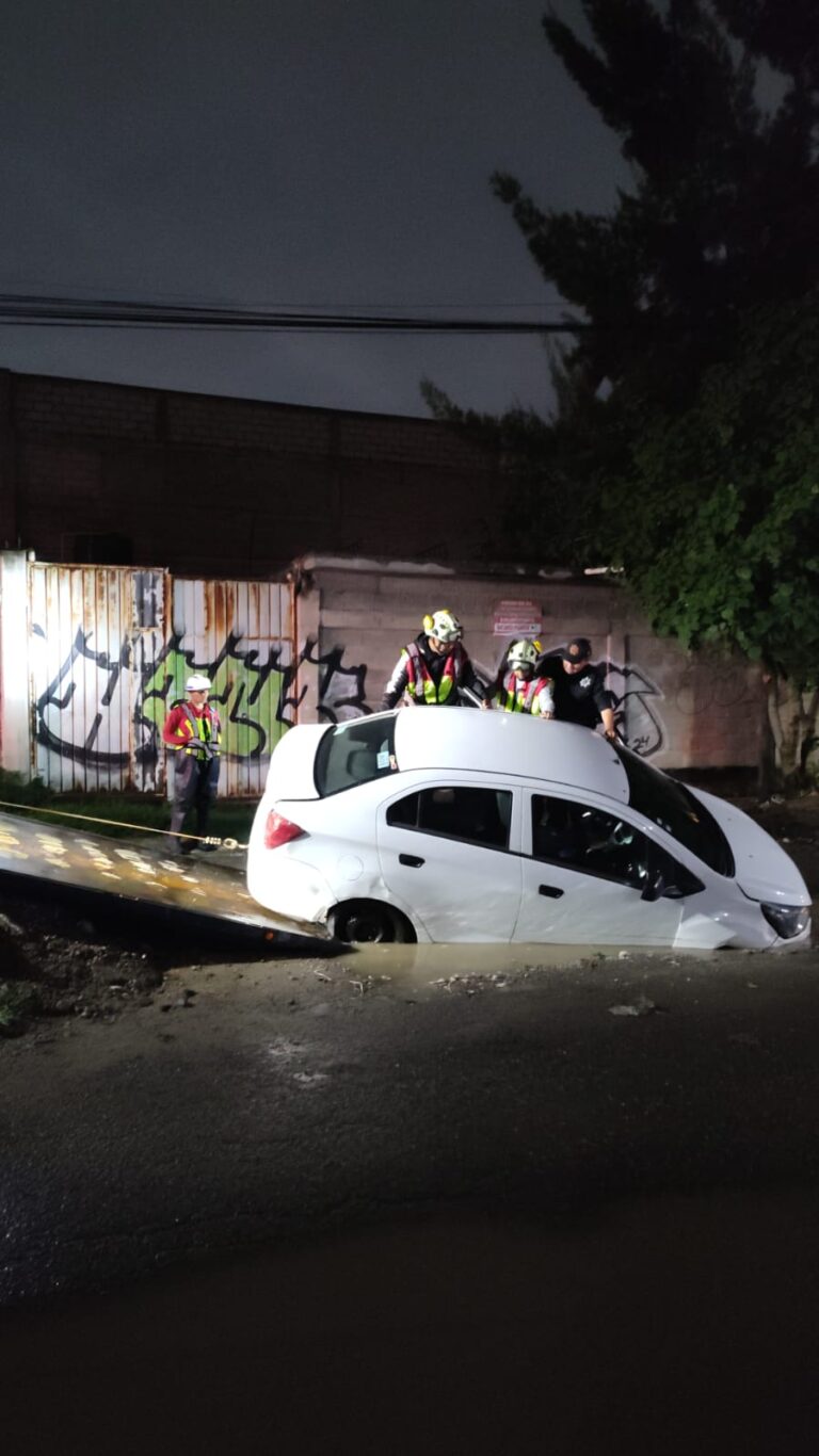 Auto cae en socavón por lluvias en El Chamizal; Bomberos rescatan al conductor